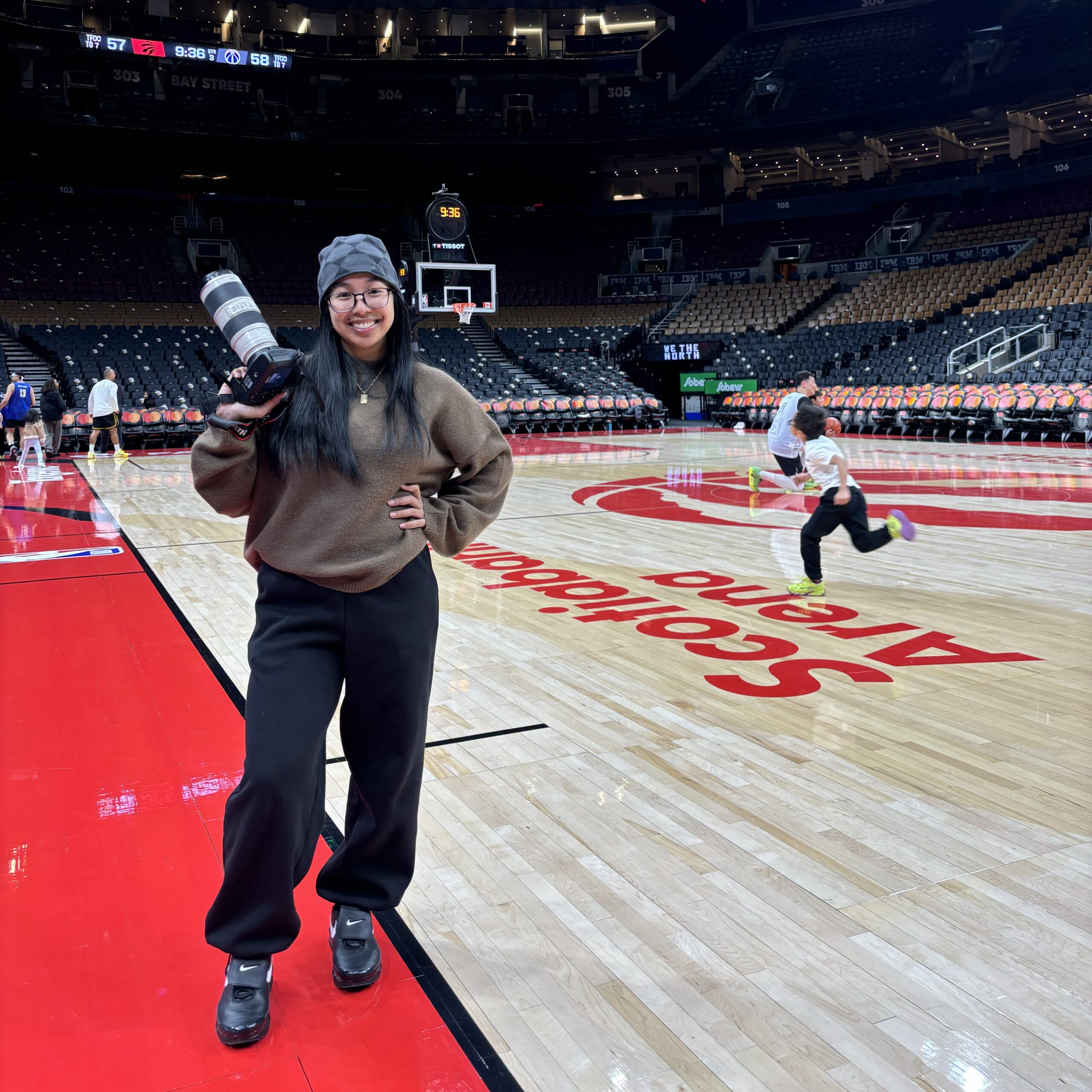 Photographer on a basketball court holding a camera