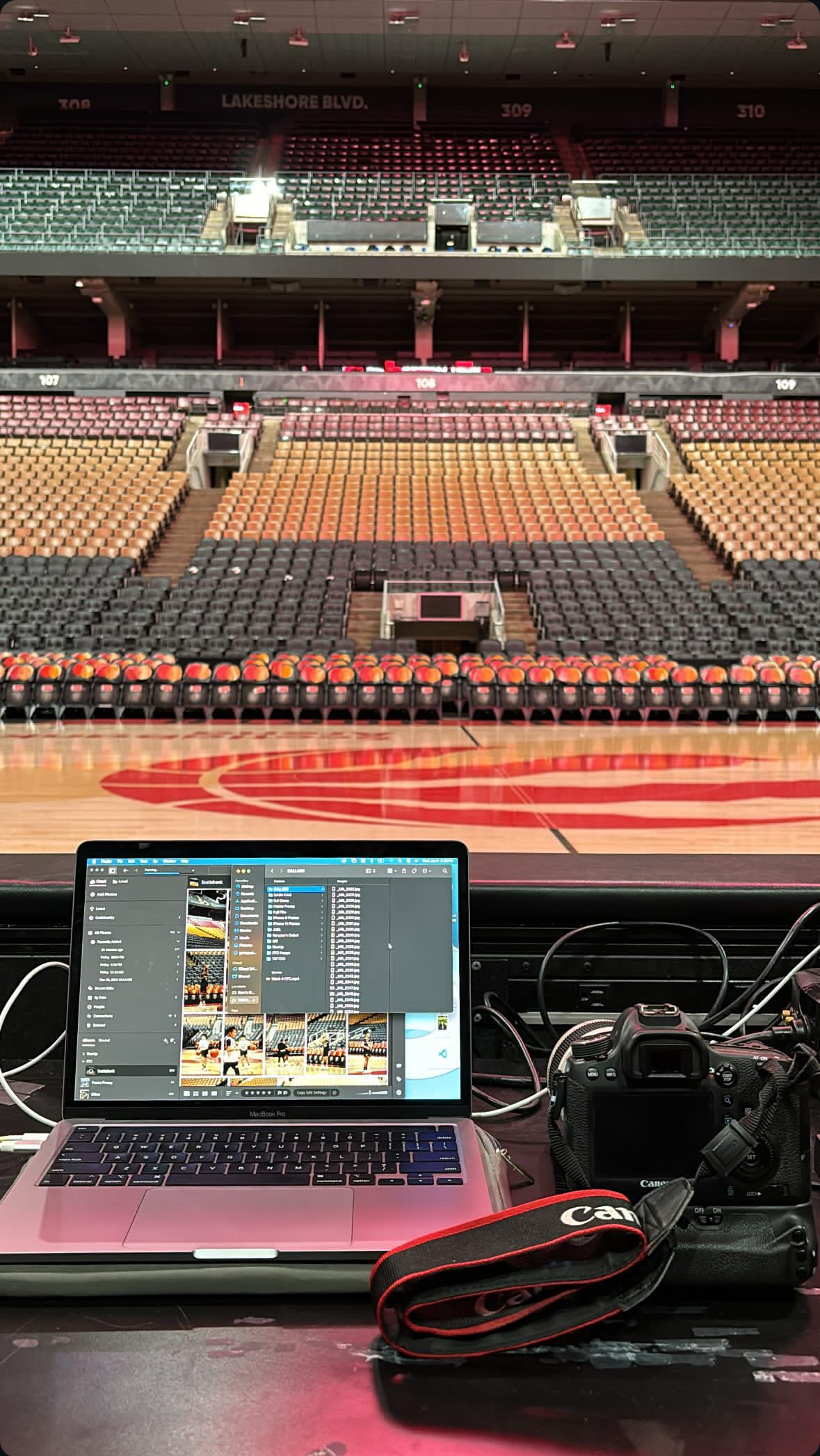 laptop and camera by a basketball court